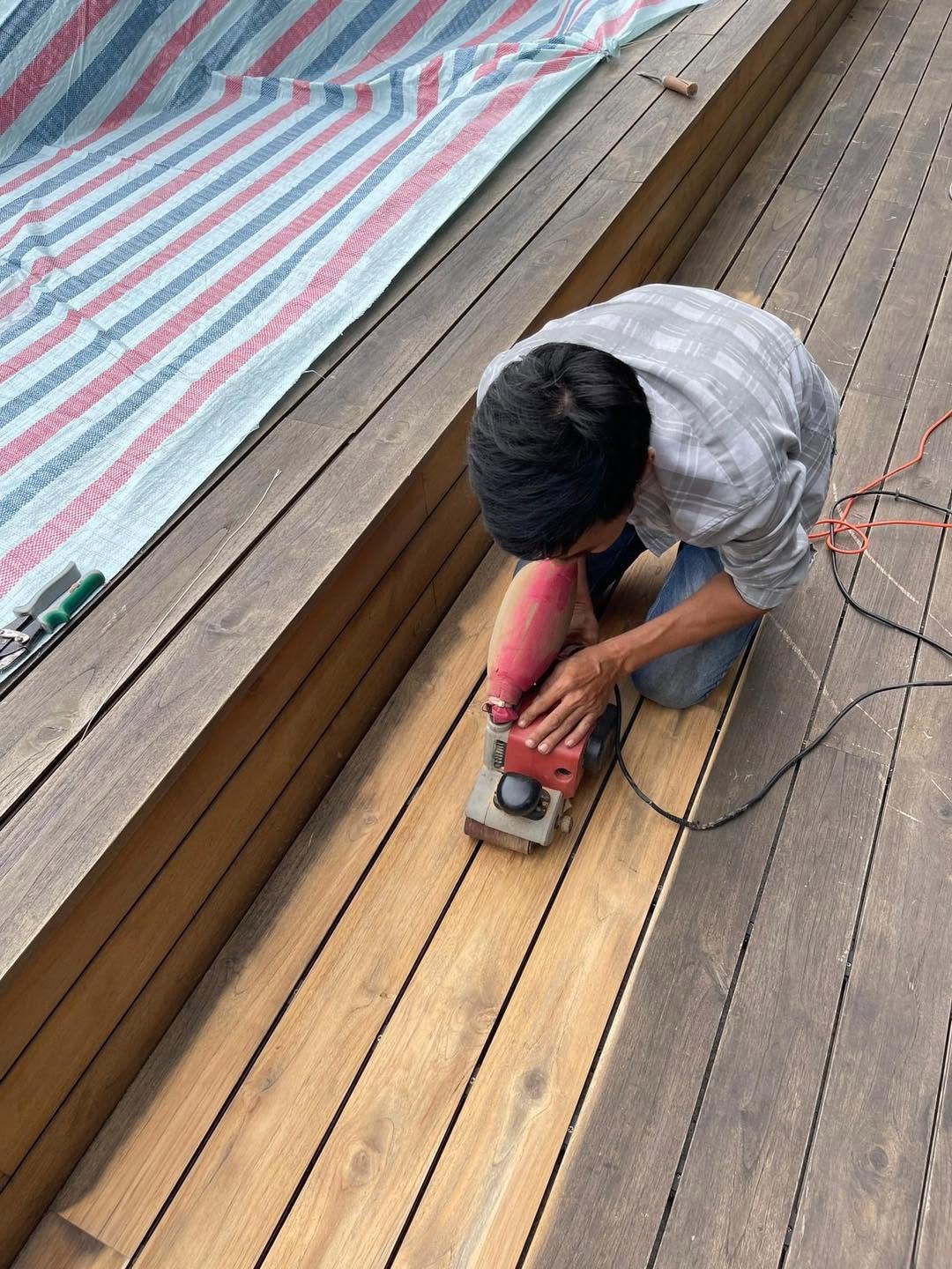 Thợ chà bề mặt bậc sàn gỗ trong quá trình bảo dưỡng